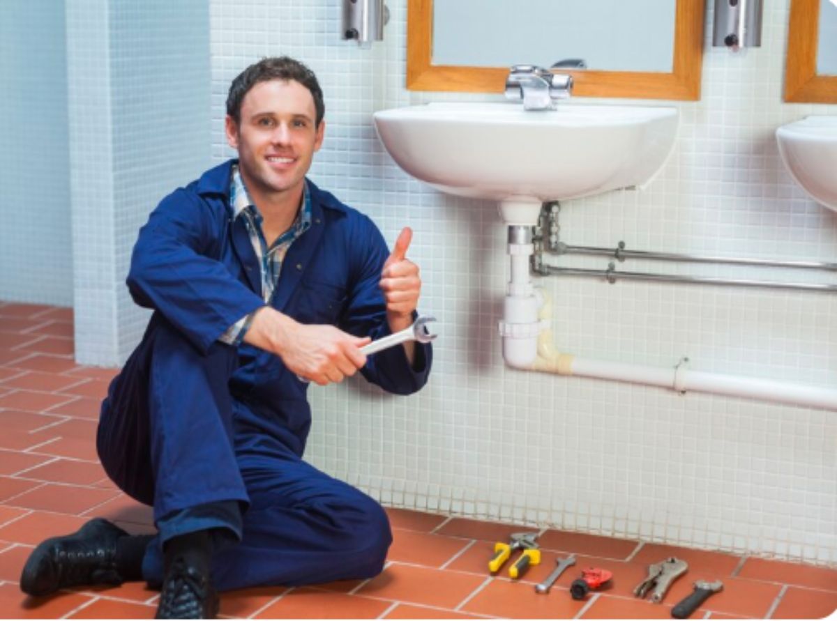 Professional plumber repairing pipe under kitchen sink to prevent water leakage
